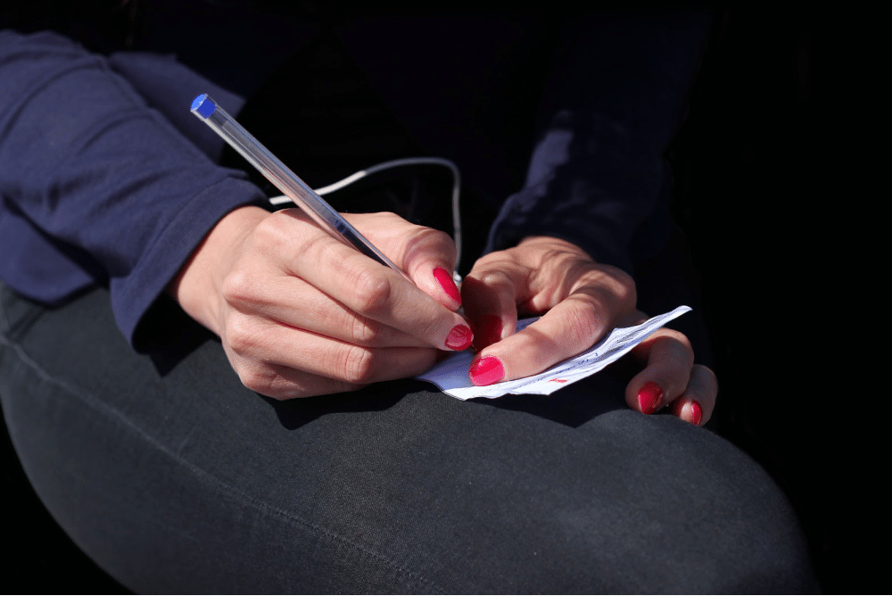 a woman stealing a moment to write a poem of a scrap of paper